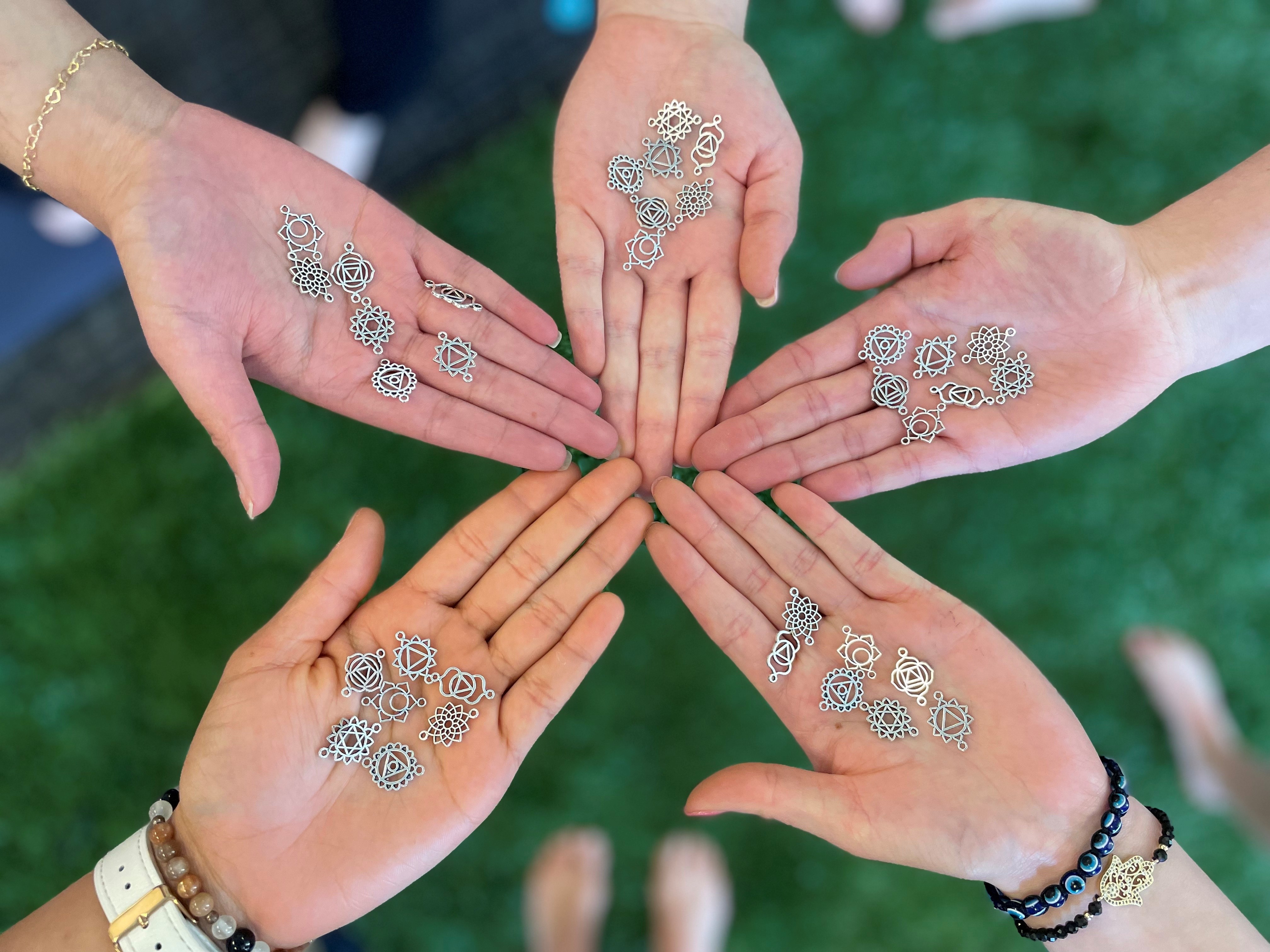hands holding yoga charms