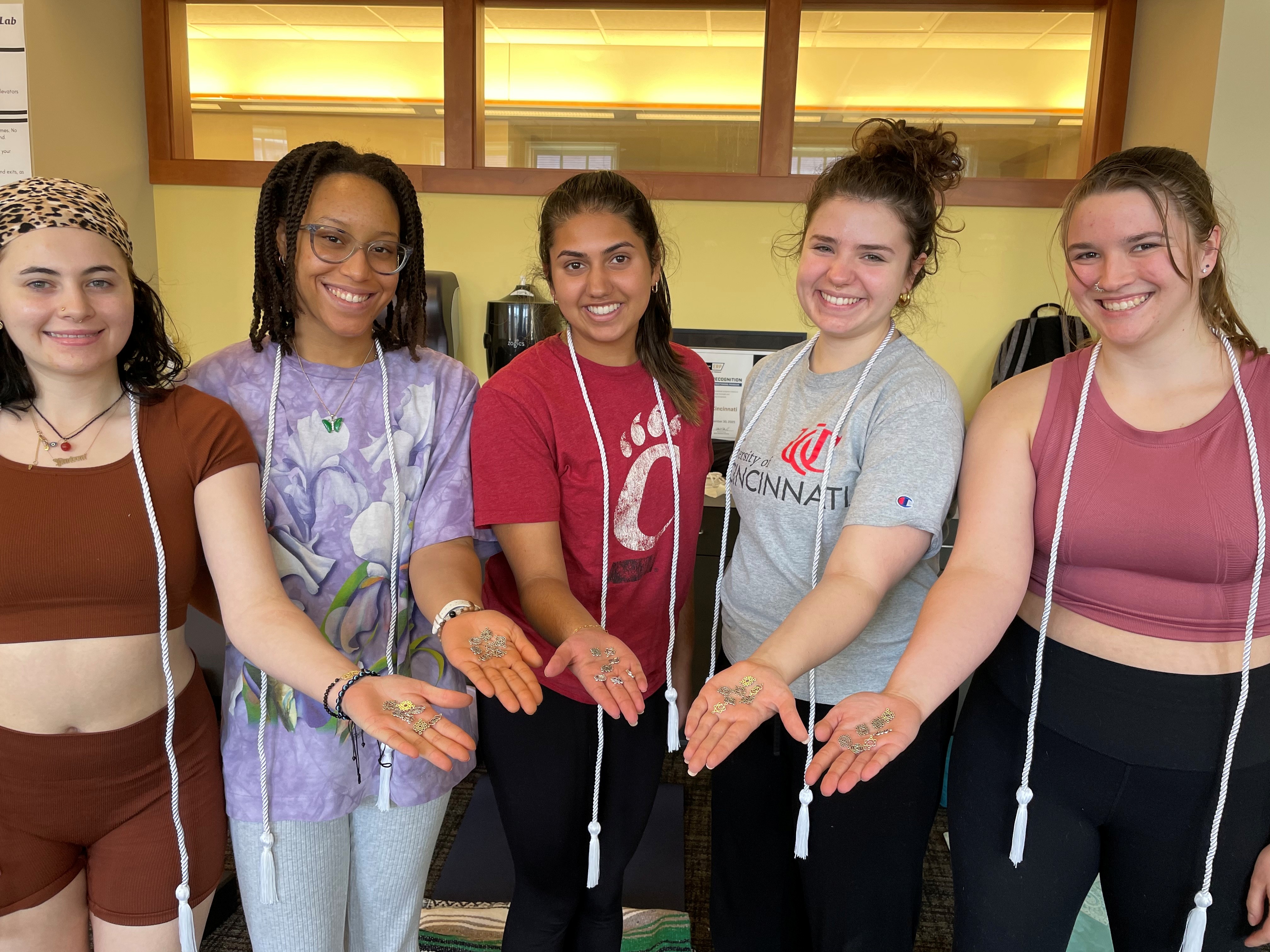 students holding yoga charms