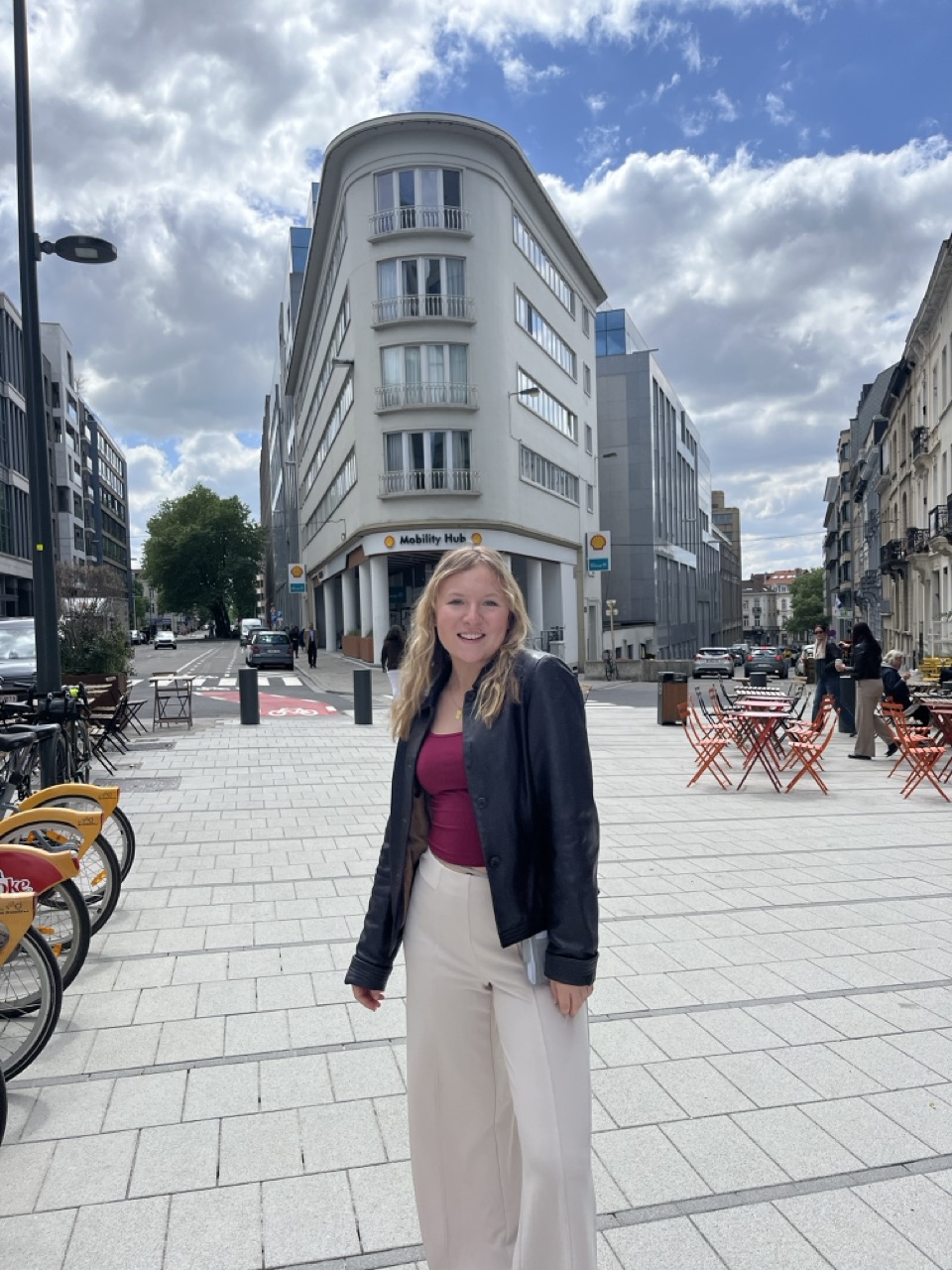 Girl with blonde hair standing on a street in Europe in professional clothing