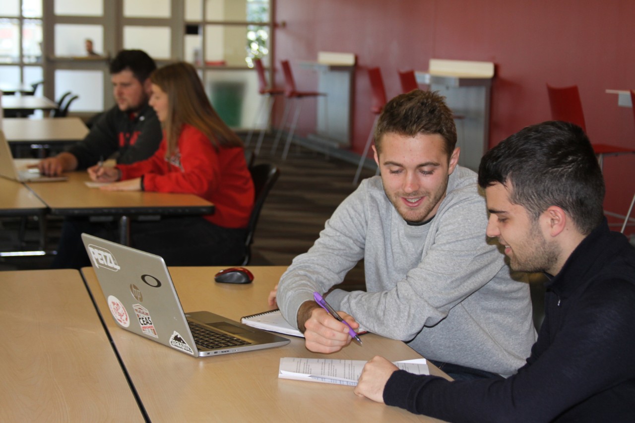 a student receiving coaching on his resume. 