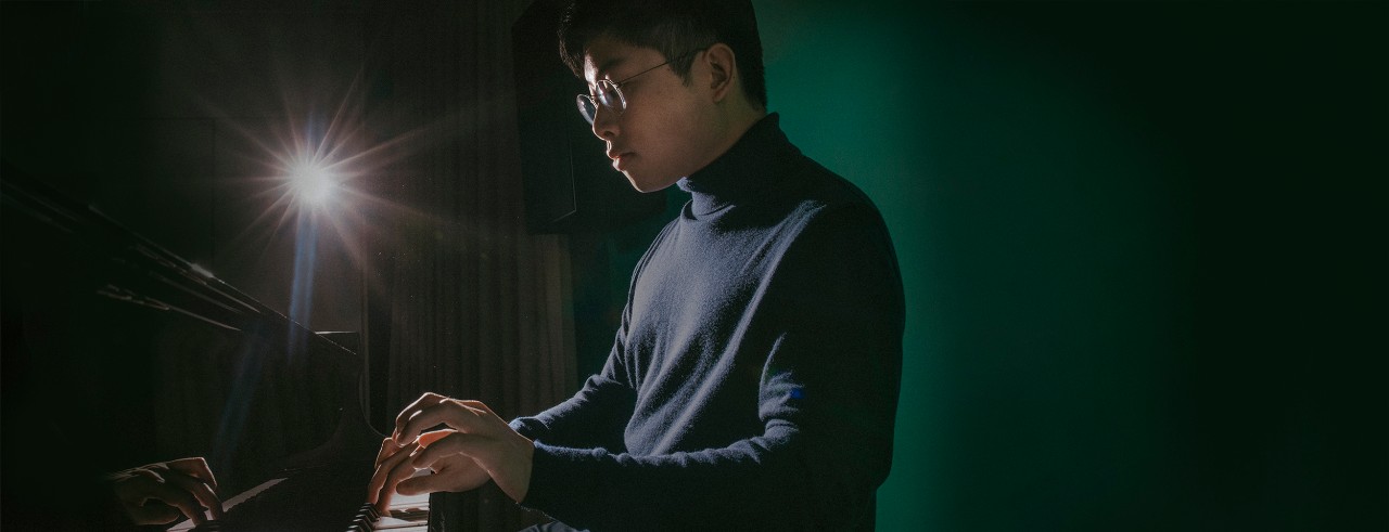 A photo of Avan Yu playing the piano.