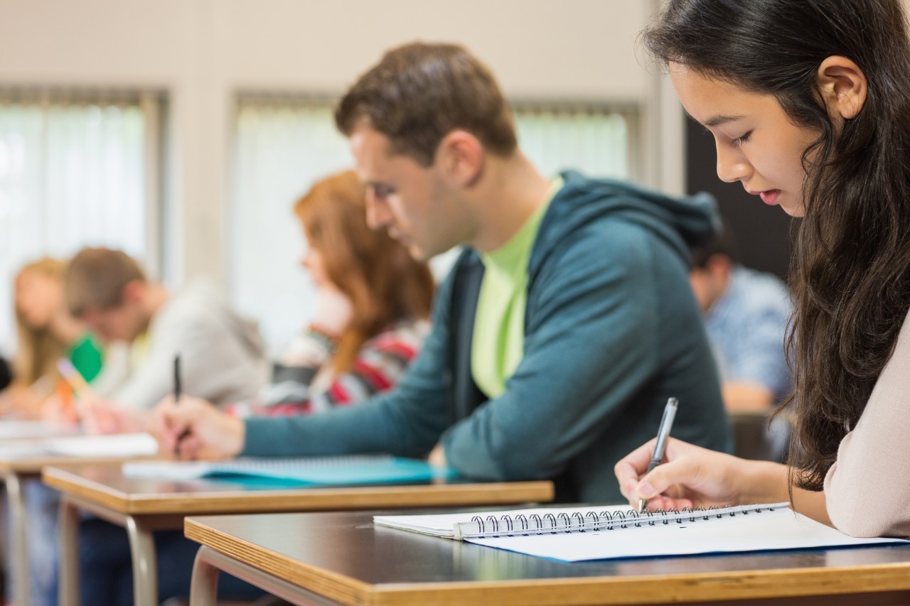 UC students learning new high income skills while writing at their desks