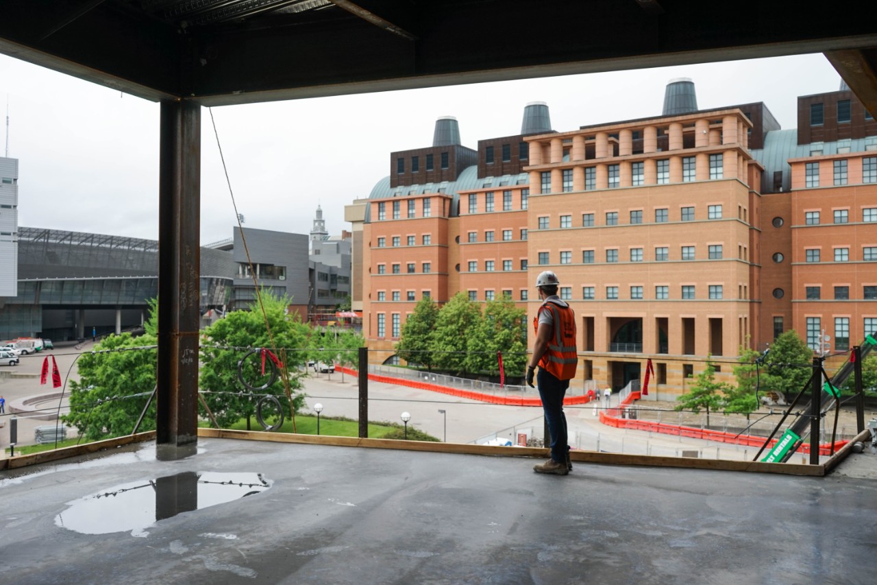 Bowersock in a hardhat and vest overlooks engineering research center from college of business.